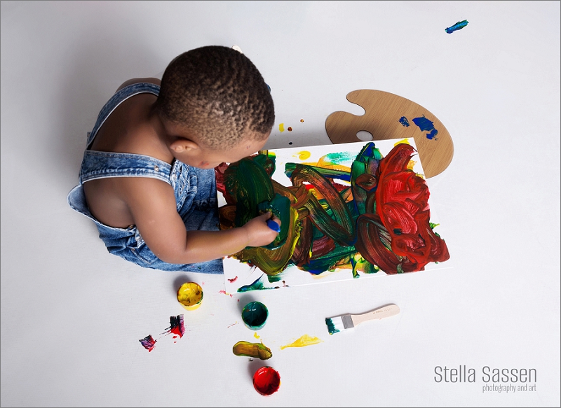 toddler painting on an easle for his birthday photo shoot